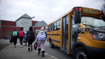 Des élèves à côté d'un bus scolaire