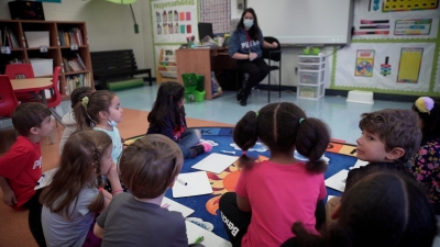 students are sitting on the floor with a teacher