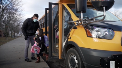 student and driver beside school bus