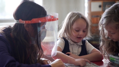 two girls show an image in a book