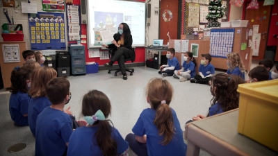 students are sitting on the floor with a teacher